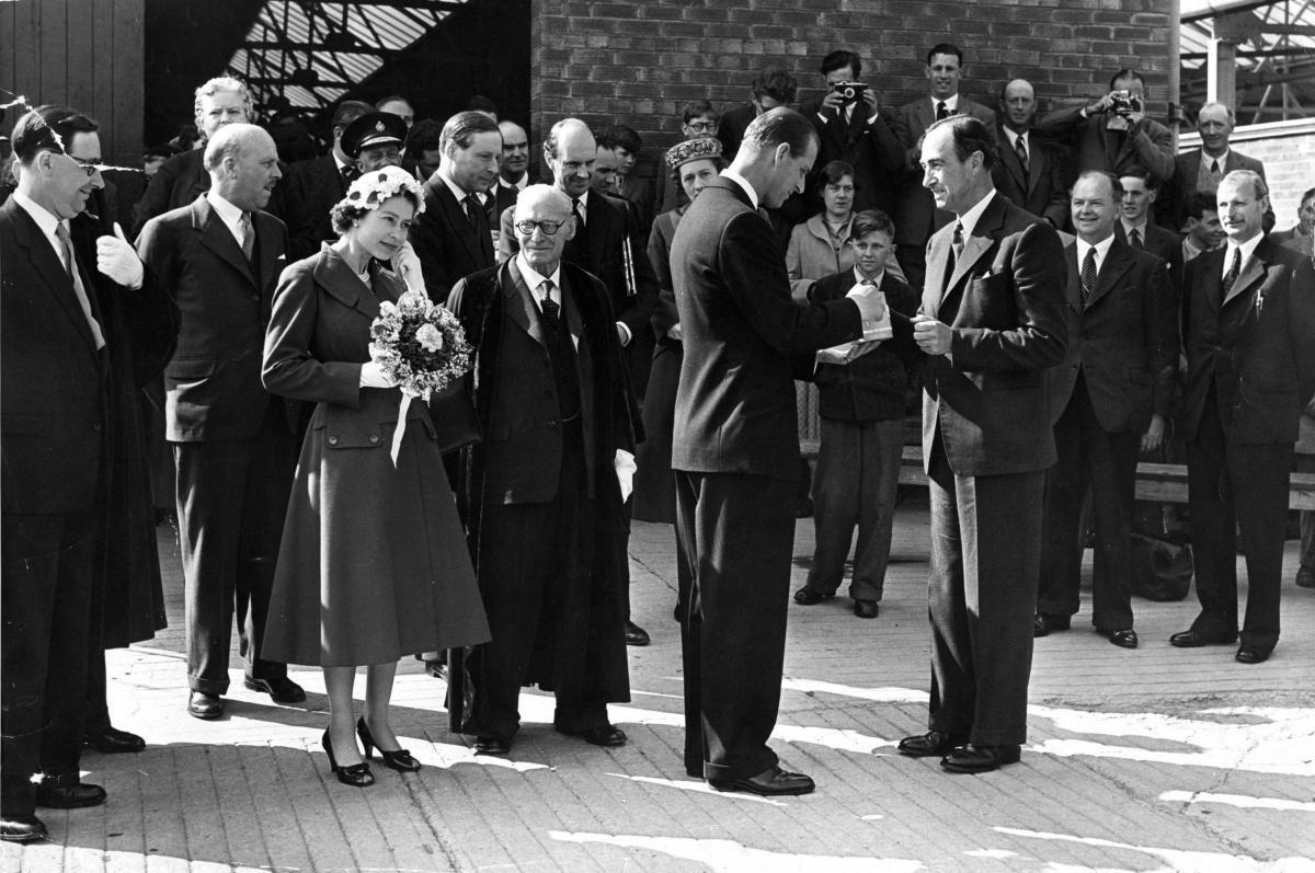 The royal visitor appears to be fiddling with her earrings as Prince Philip receives a traditional cider mug from Howard Bulmer on a visit to a cider factory. Photo: Derek Evans Archive