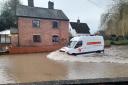 An O'Connor Utilities van driving through floodwater in Eardisland