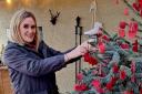 Vicky Kaye hangs the 1,000th heart on the tree