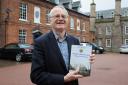 Former Headteacher Howard Tomlinson has written a book on the history of Hereford Cathedral school. Howard with his book in front of School House, the oldest building still in use at the school.