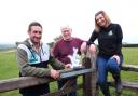 John Craven with Sam and Emily Stables from We are Farming Minds at their farm in Herefordshire. Picture contributed by National Lottery Promotions