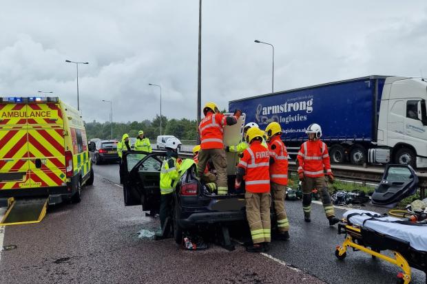 The roof is cut off a car by firefighters after a crash on the M42 yesterday