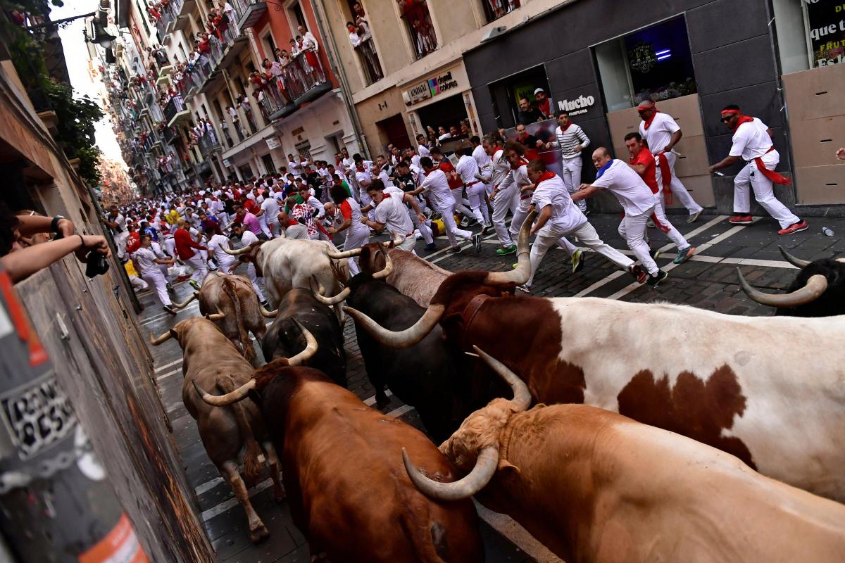 People running through the streets ahead of bulls