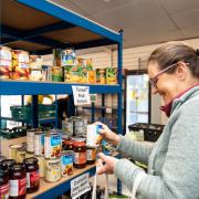 A volunteer stocking the shelves at Ledbury Food Bank