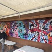 Artist Tom Phillips with one of the murals he's painted at the Brewery Inn