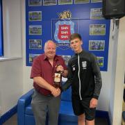 Les Coultas is presented with a bottle of whisky on his retirement from young official James Wilson