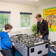 Matt Creed playing table football with the children at the breakfast club